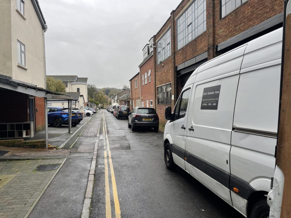 ESV Removals van with East Sussex Van branding parked on a narrow town street, double yellow lines on one side and parked cars on the other