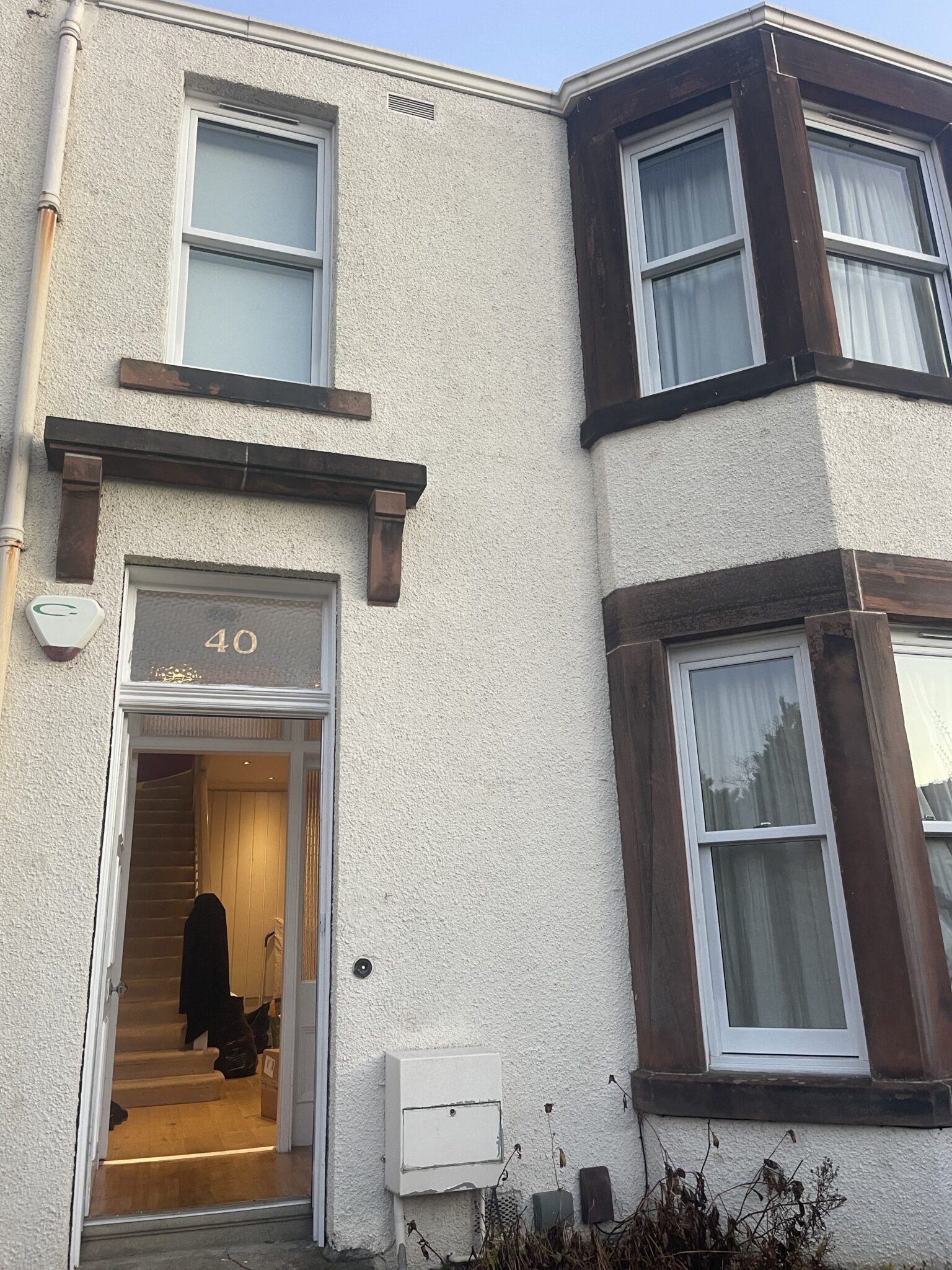 Front view of a two storey Edinburgh house with the front door open and staircase visible, ready for ESV Removals to unload a long distance Brighton move.