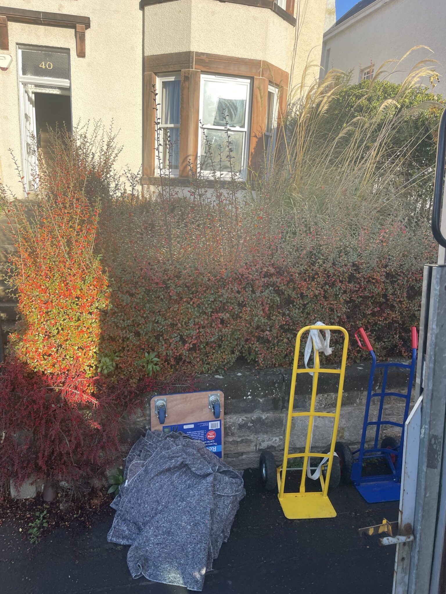 Moving blankets, a furniture dolly and sack barrows set up outside an Edinburgh house during unloading by ESV Removals.