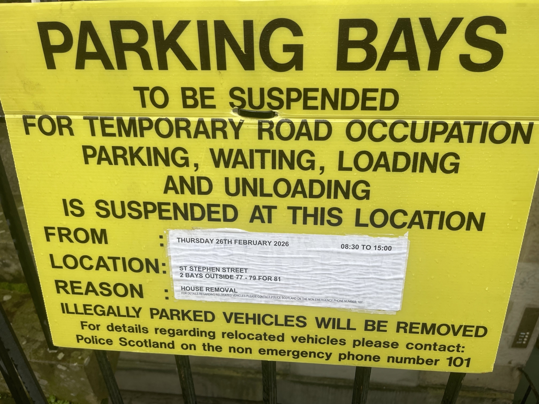 Close up of an Edinburgh “Parking Bays To Be Suspended” sign showing a temporary road occupation for house removal loading and unloading.