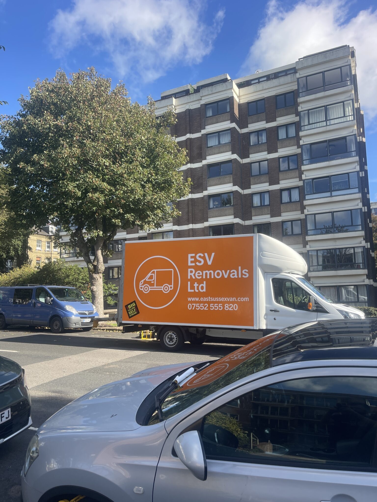 ESV Removals Ltd Ford Transit Luton with orange van branding showing the logo, eastsussexvan.com and 07552 555 820