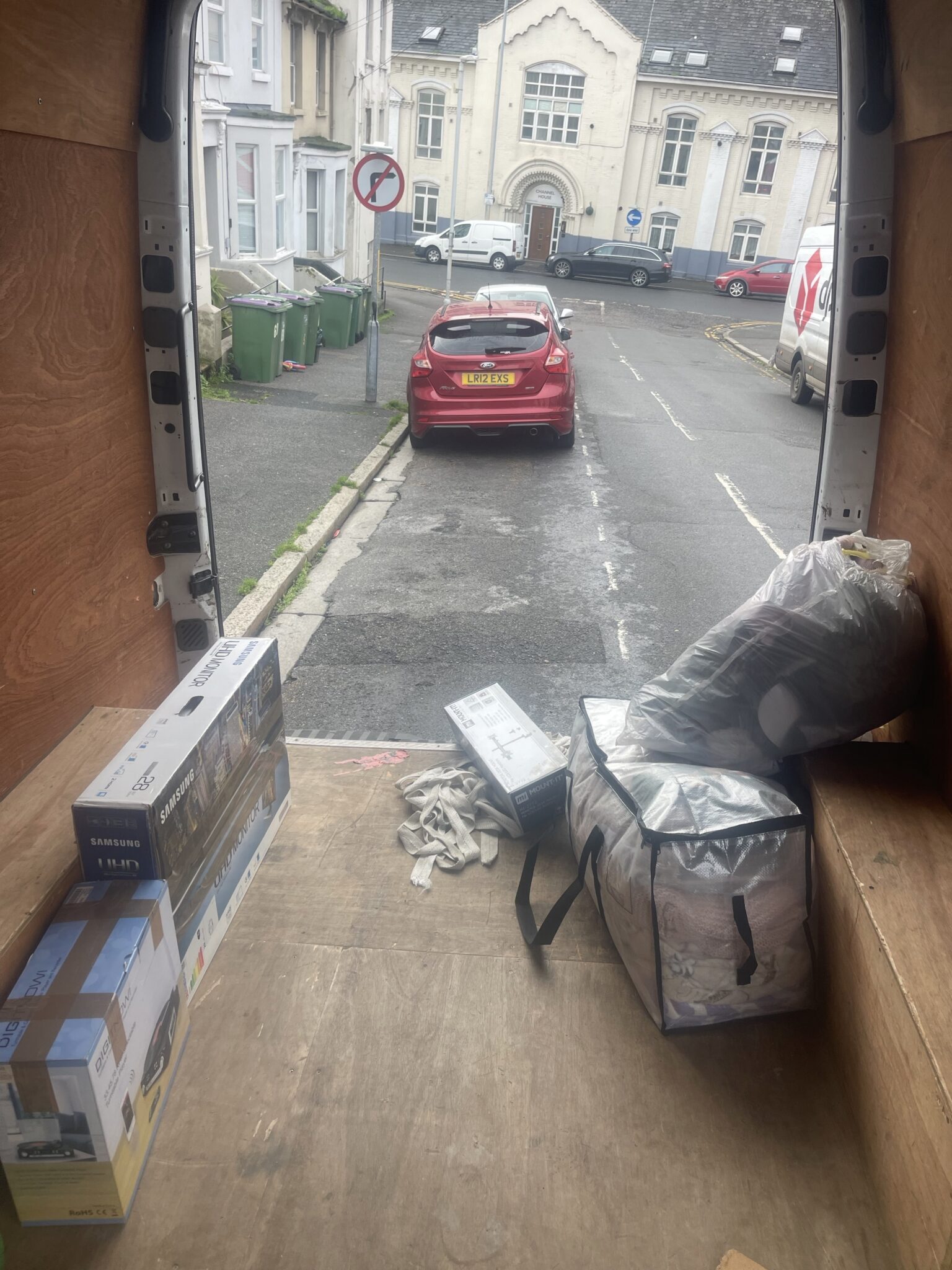 Inside a Mercedes Sprinter with a small studio flat load on Clarence Street in Folkestone looking out of the open doors during a Kent to Sussex man and van move.