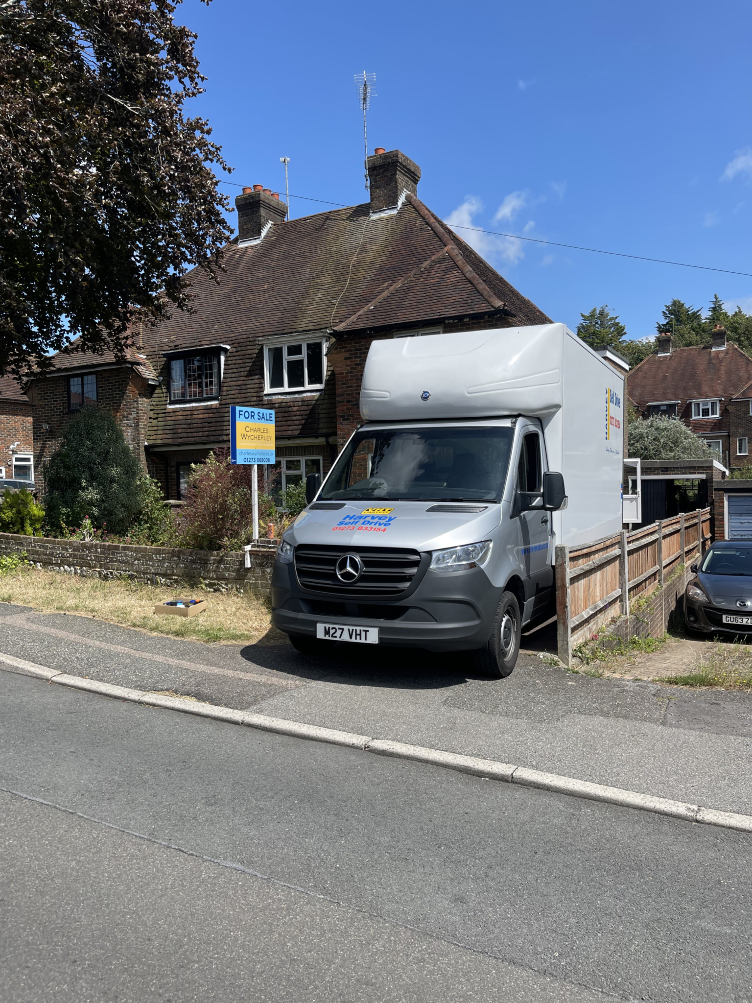 ESV Removals van outside a Sussex home with a ‘for sale’ board, helping a Brighton family move in on completion day once stamp duty is paid.