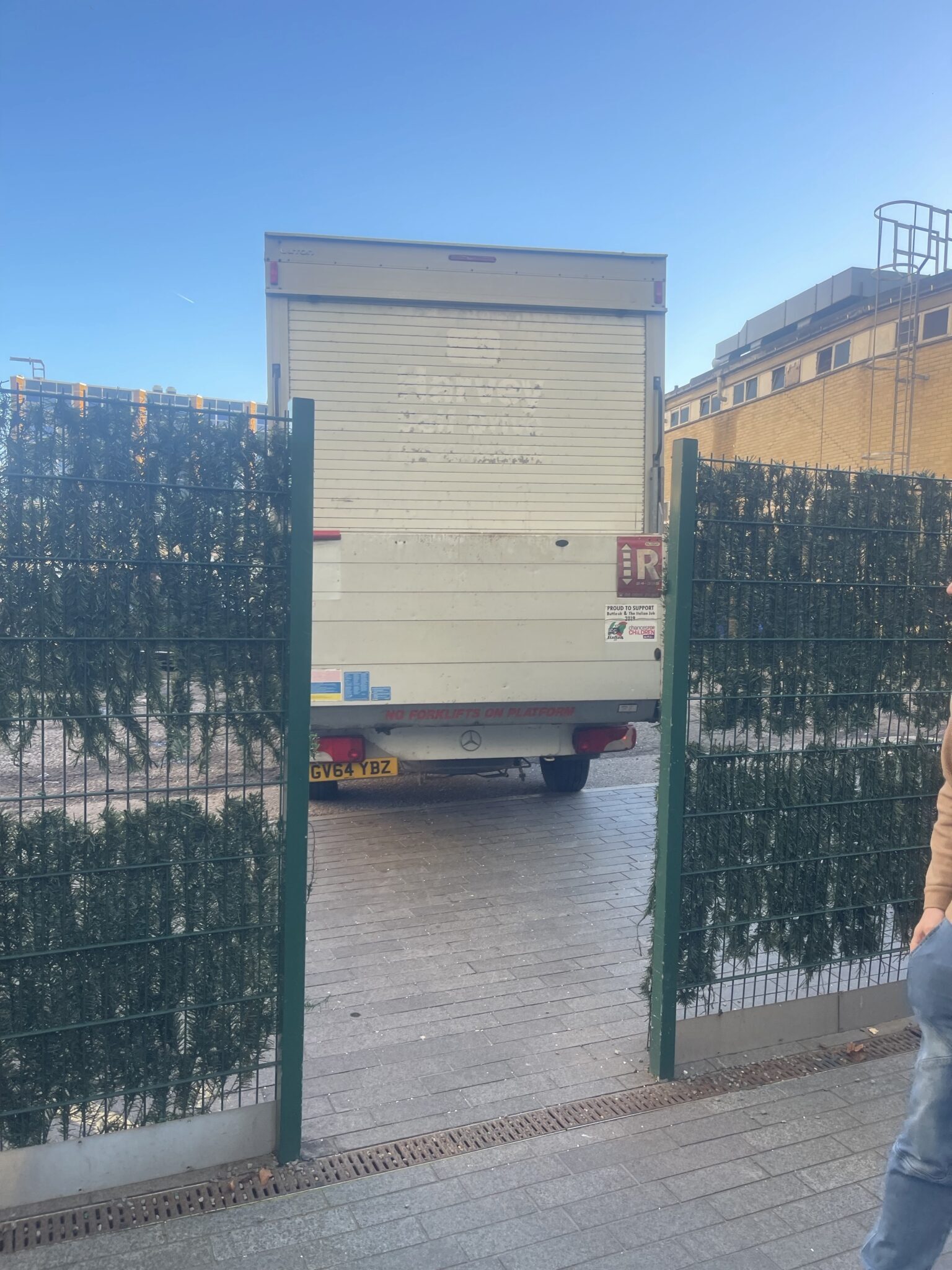 Rear of a Luton removals van positioned through a narrow entrance gate, showing tight access where legal stopping and carry route planning matter.
