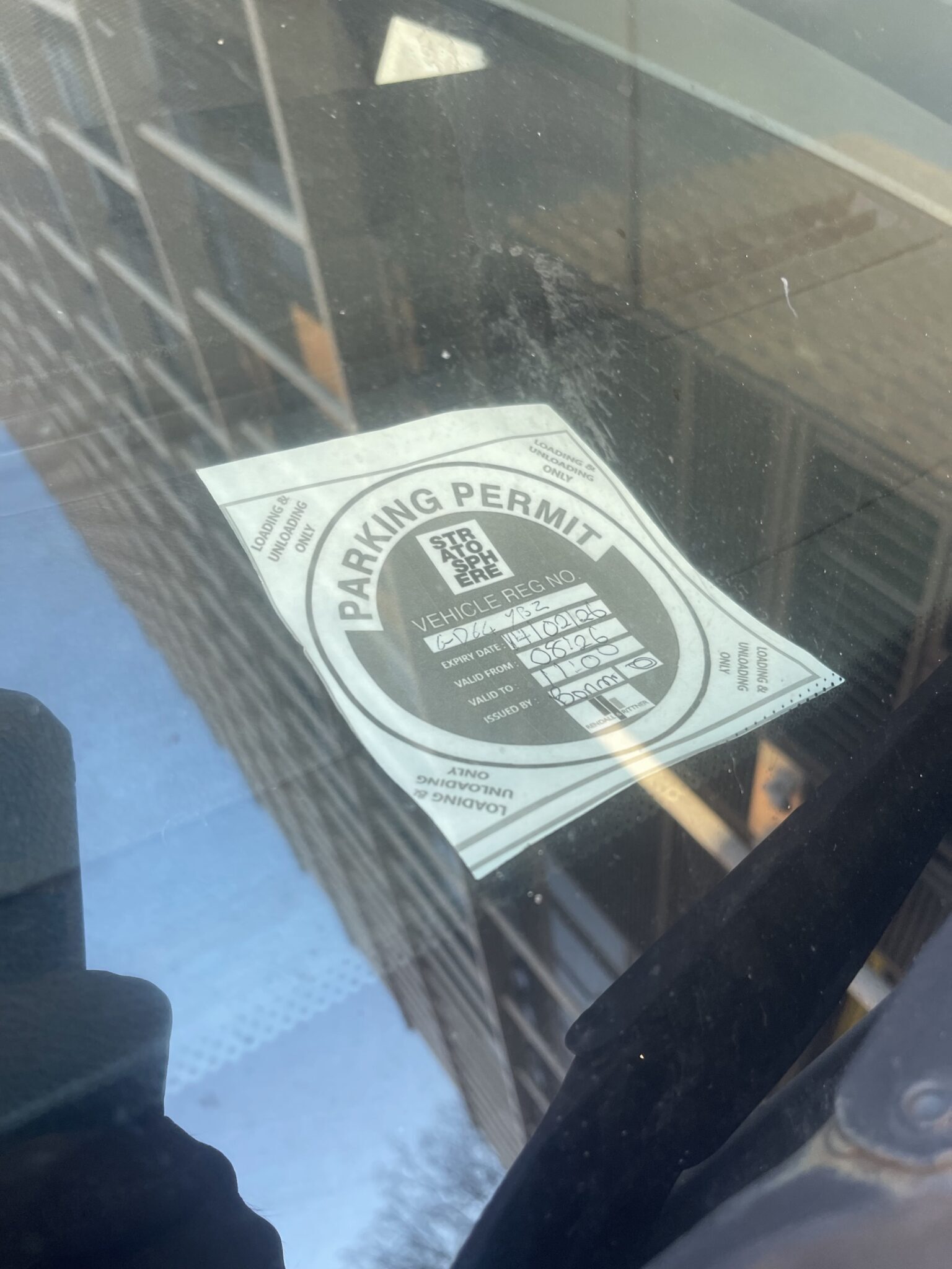 Close up of a Stratford parking permit displayed inside a van windscreen for loading and unloading during an E15 move.