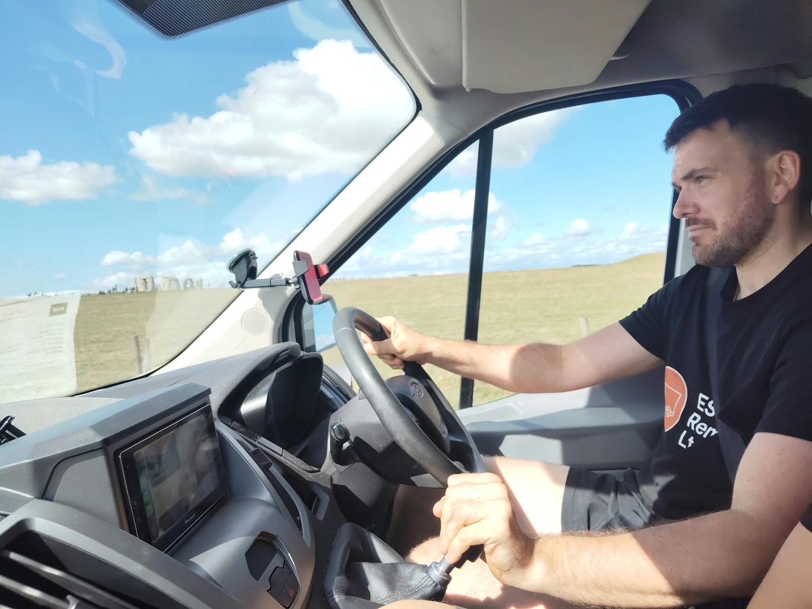Peter Hawes driving the ESV Removals Ford Transit Luton past Stonehenge on the A303, wearing a branded ESV Removals t-shirt
