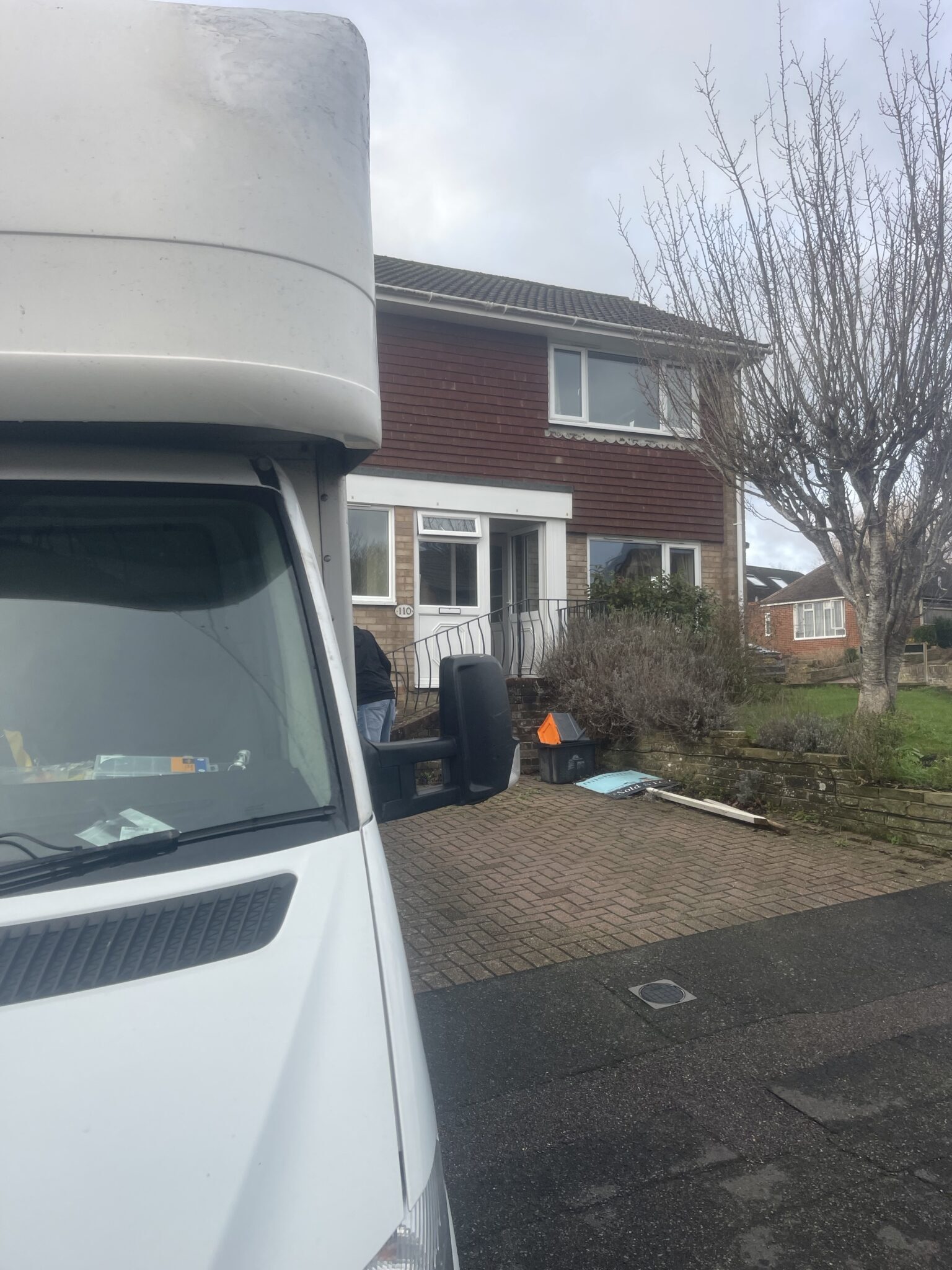 ESV Removals Luton van parked beside a semi detached house with a tile hung upper storey, steps up to the front door and a block paved drive