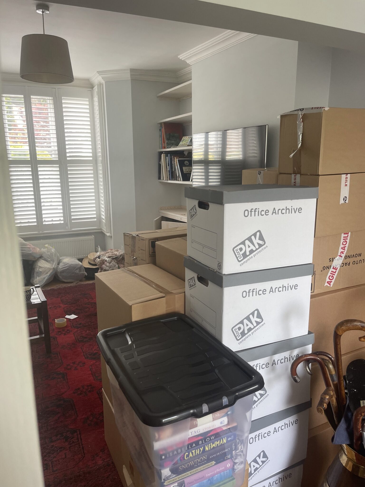 Packed boxes and archive crates stacked in a Lewes townhouse room during a professional packing day