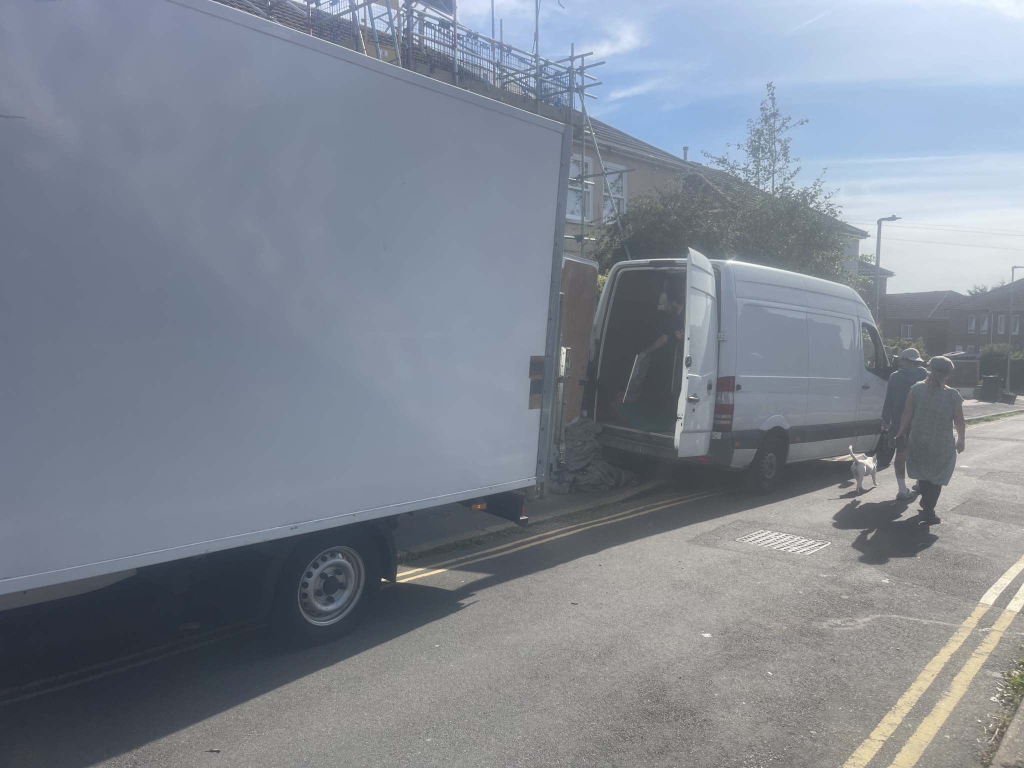 ESV Removals Luton van and Sprinter parked on a residential street, with crew members walking between the two vans