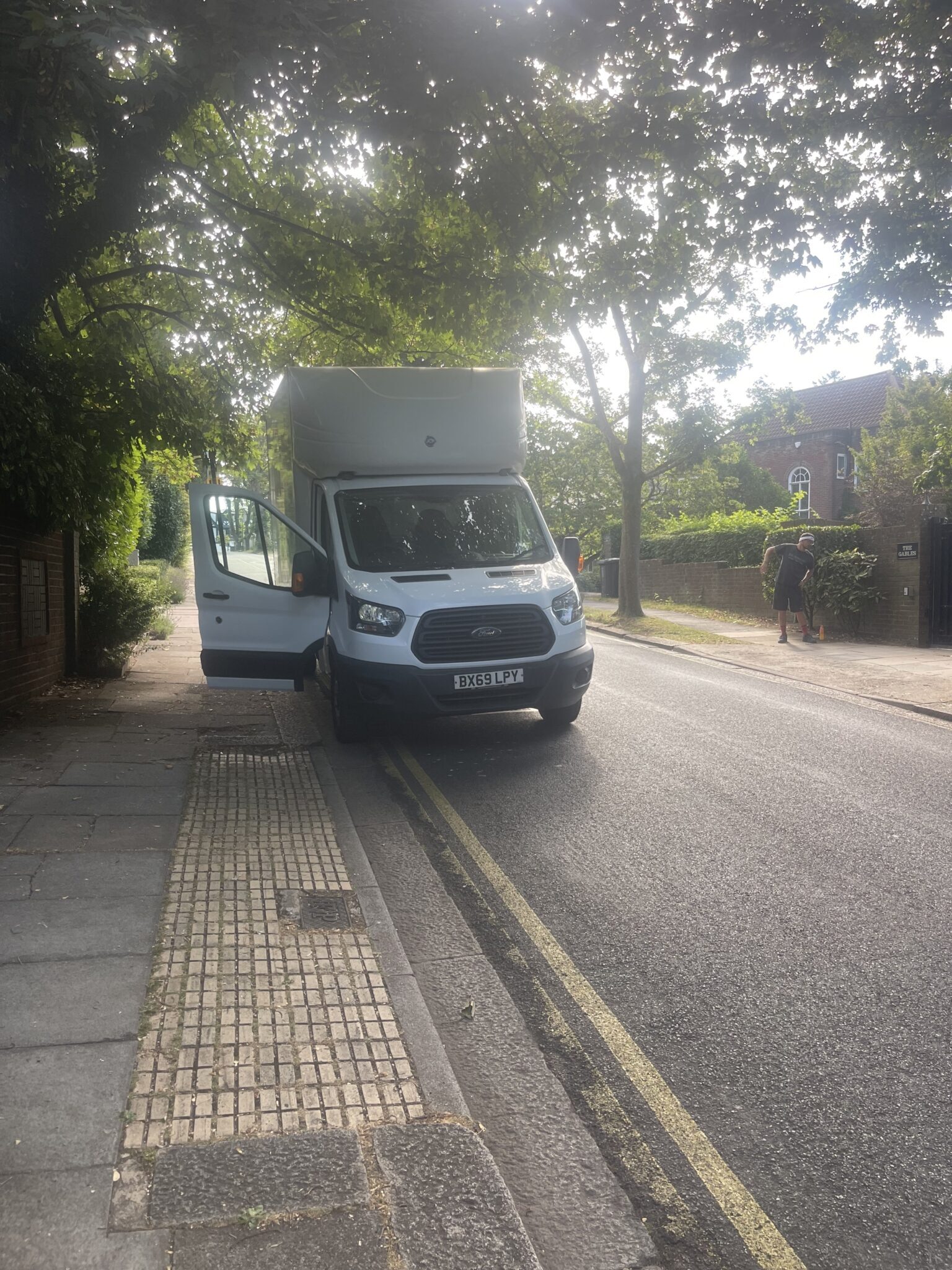 new Ford Transit Luton on a tree-lined residential street