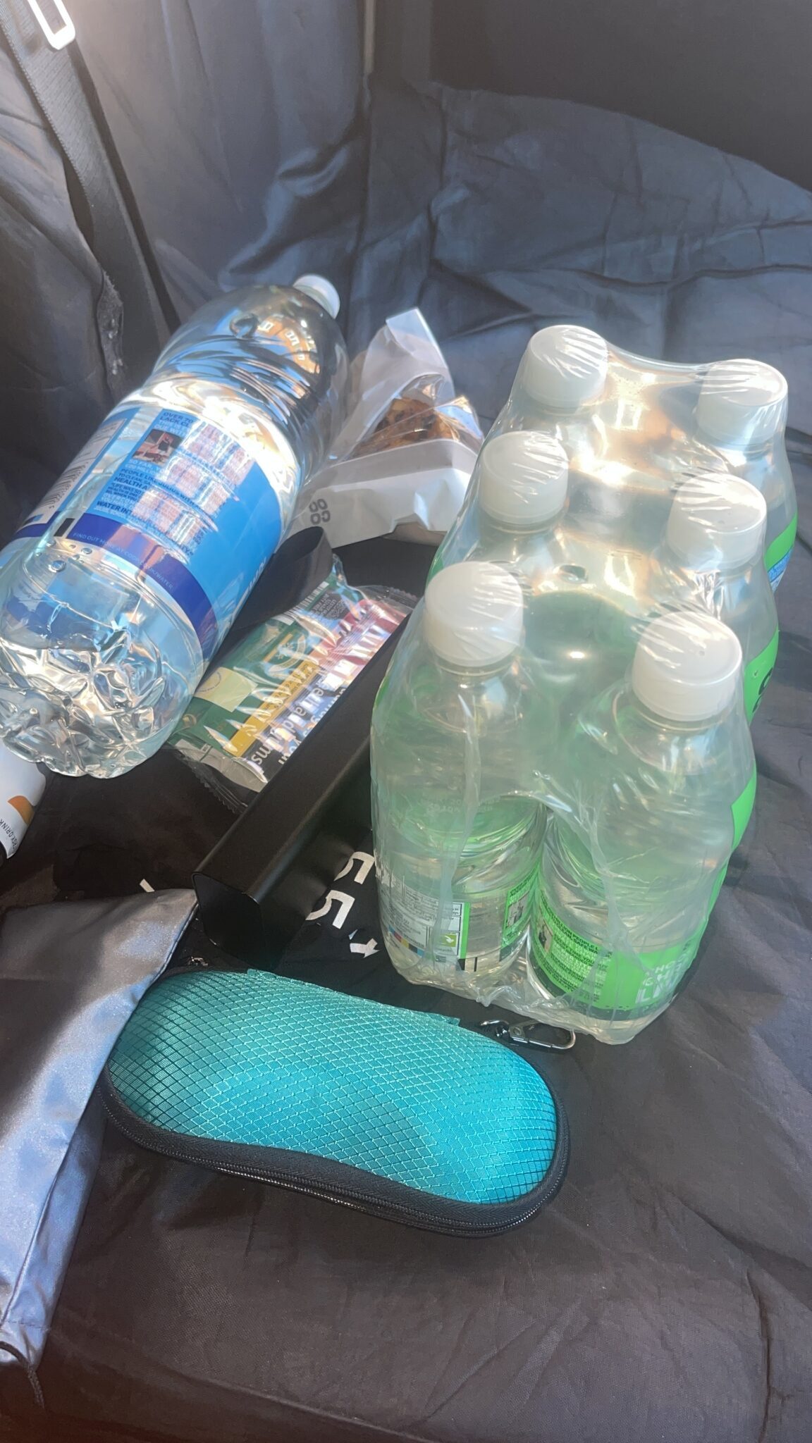 Bottled water, snacks and a sunglasses case on the van seat, stocked for driver breaks on a removal run from London to Hove.